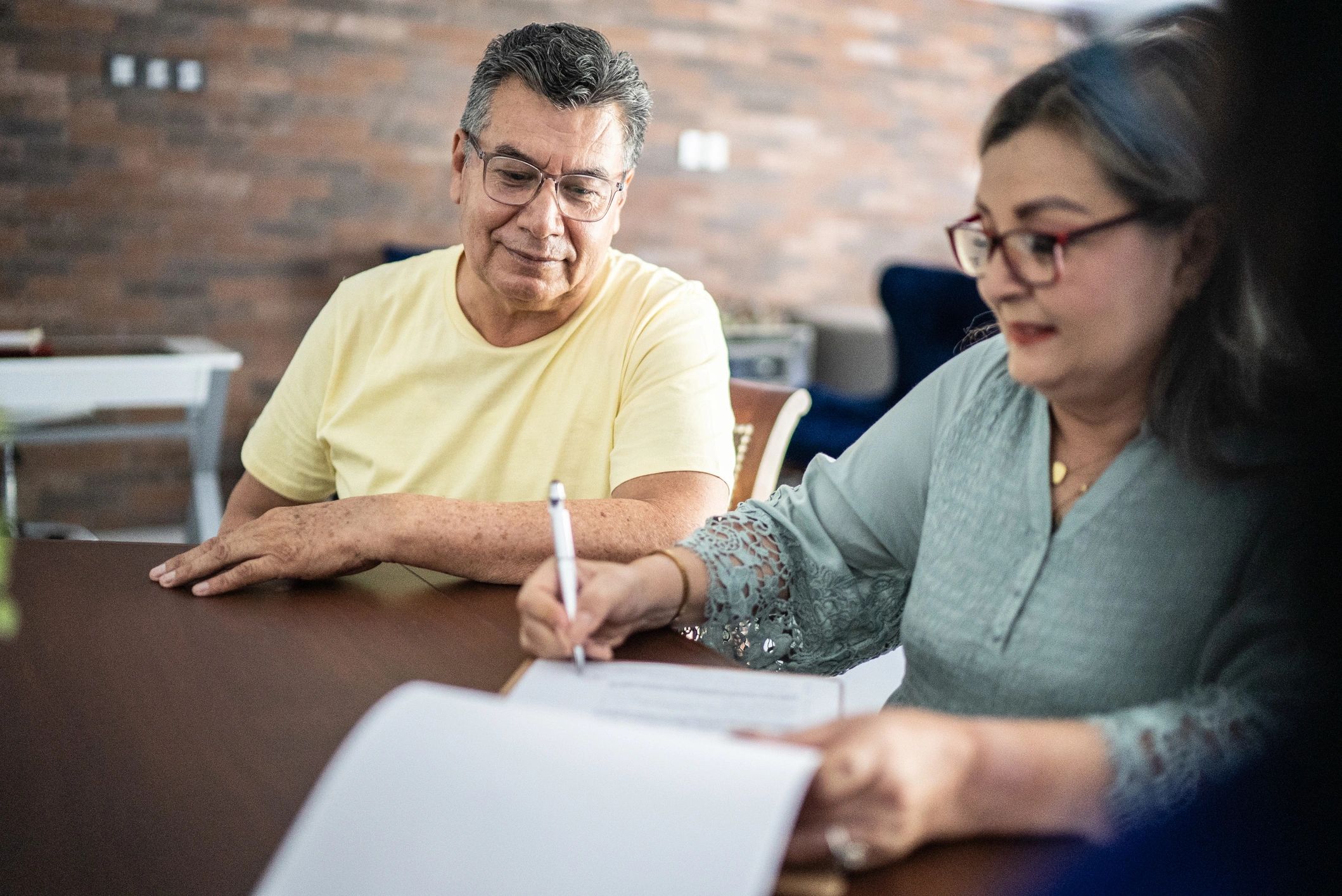 Clients reviewing and signing home purchase paperwork with guidance
