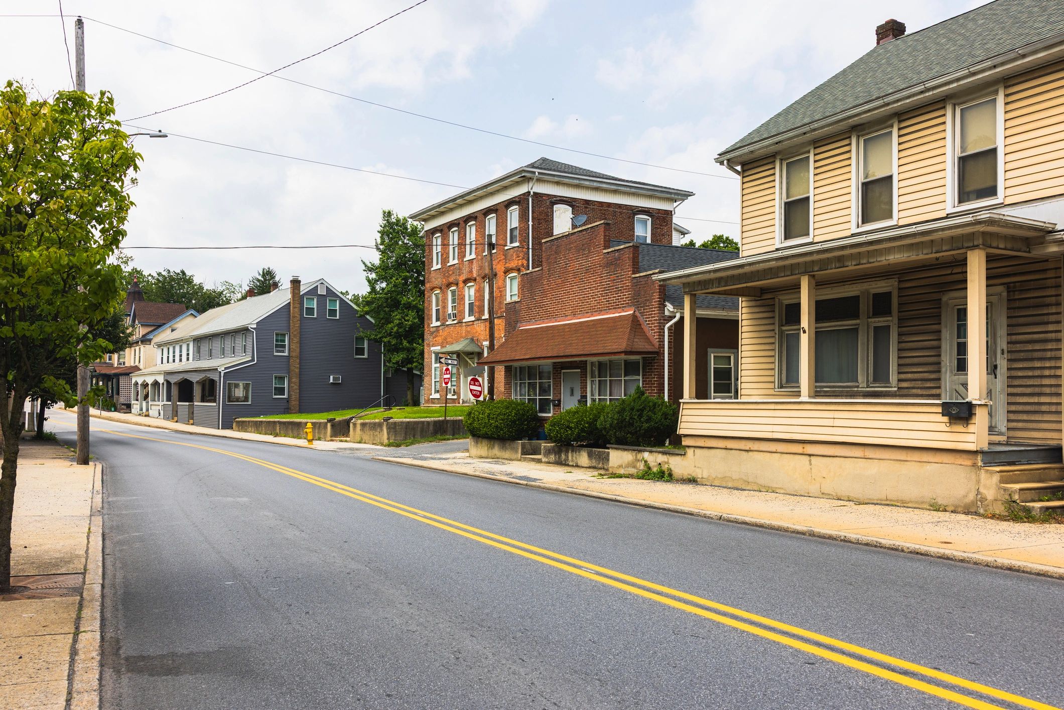 Quiet small-town main street with homes and storefront building